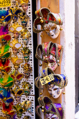 Traditional venician masks on shelves in souvenirs shop in Venice, Italy