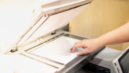 Businesswoman hand lay down or take papers from laser copy machine for process paperwork on laser...