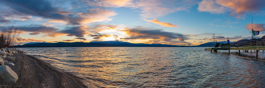 Panoramic nature sunset in northern Canada taken during fall, autumn over a stunning lake with blue sky and dock. 