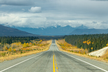 Fototapeta na wymiar Road trip, tourism, travel themed shot heading directly towards huge mountain landscape in fall, autumn during September in northern Canada, Yukon Territory, Haines Junction. 