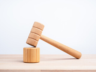 A wooden judge gavel and soundboard, toys on wooden desk and white background, minimal and eco style. Justice concept.