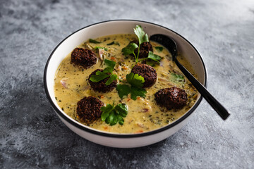 vegan green curry with mixed vegetables and plant-based meatballs, healthy plant-based food