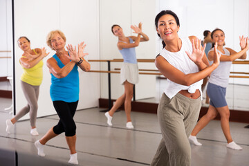 Positive women of different ages dancing strip plastic in a dance class
