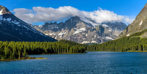 Mount Gould - Spring morning clouds hovering over massive and rugged Mount Gould at shore of Swiftcurrent Lake. Many Glacier, Glacier National Park, Montana, USA.