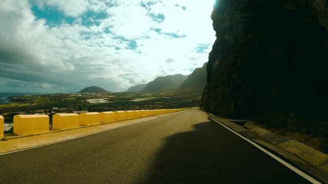 Driving along a road on the side of a mountain in Punta de Teno in Tenerife. 