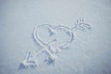 Heart with arrow, drawn in snow. Love symbol painted on white snowy background. Romantic relationship concept.