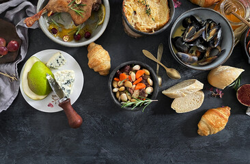 French dishes and appetizers served on dark background.