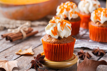 Homemade autumn pumpkin cupcakes or muffins with nuts and spices