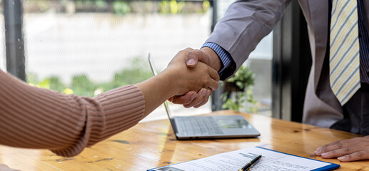The job interviewer and the job applicant are holding hands after the job interview is finished. The concept of recruiting employees to work in the company, vacant positions.
