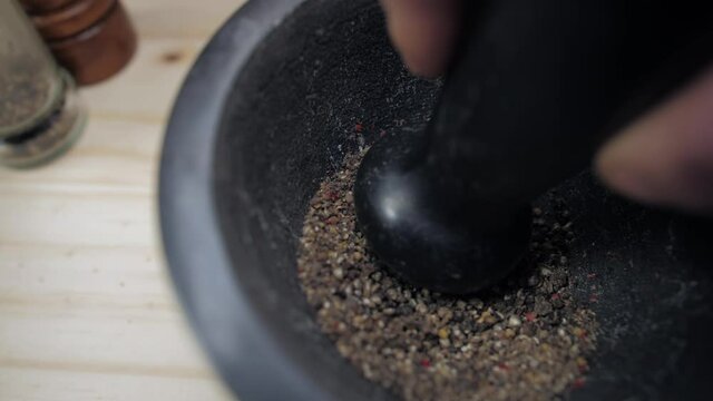 grinding peppercorns with mortar and pestle slow motion