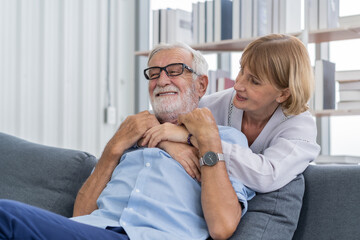 Fototapeta premium Happy senior couple family, caucasians mature, adult lover and retired man, woman embracing, hugging make romantic, empathy on sofa, couch at home together. Smile, husband and his wife lifestyle.