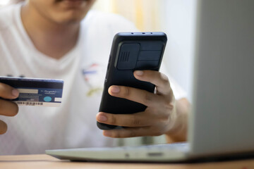 man hand using mobile smart phone, online payment, banking and online shopping at the home.