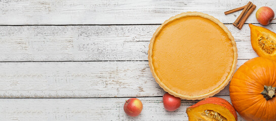 Tasty pumpkin pie on white wooden background