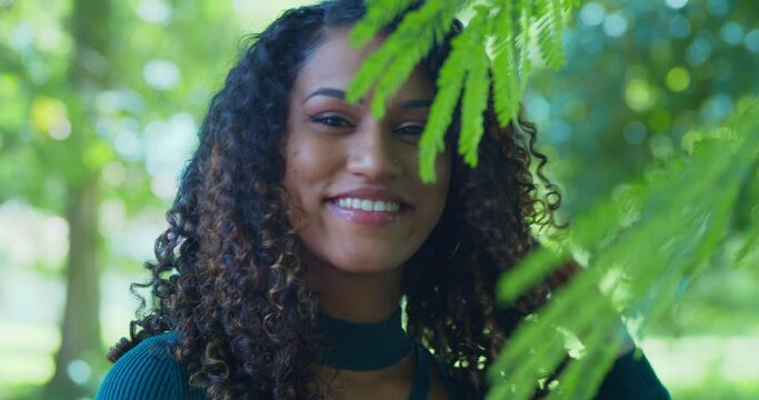 A close up of a young east indian girl with a nose ring smiling on a sunny day