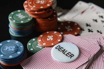Poker chips and playing cards on dark background