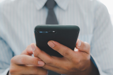 business man hand holding mobile phone.