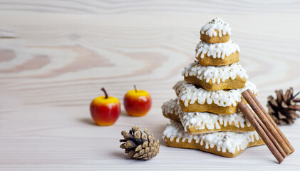 sweet christmas dessert on a white wooden background, christmas tree made of gingerbread, stacked on top of each other and covered with sugar icing, copy space