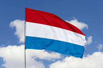 Luxembourg flag isolated on the blue sky background. close up waving flag of Luxembourg. flag symbols of Luxembourg. Concept of Luxembourg.