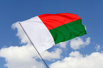 Madagascar flag isolated on the blue sky background. close up waving flag of Madagascar. flag symbols of Madagascar. Concept of Madagascar.