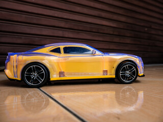 Fototapeta premium yellow toy car with reflection on the floor 