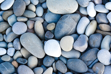 Fototapeta na wymiar Abstract background with round pebble stones. Stones beach smooth. Top view.