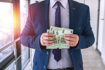 Business man in a suit counts euro banknotes