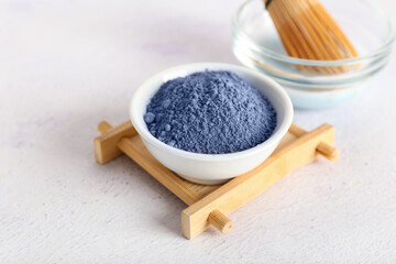 Bowl of powdered blue matcha tea on light background