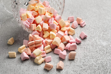 Glass bowl with tasty marshmallows on grey background, closeup