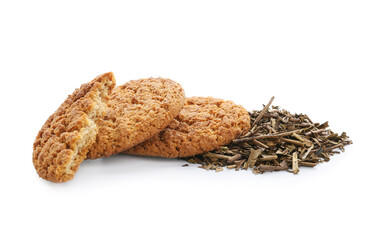 Tasty hojicha cookies and dry leaves on white background