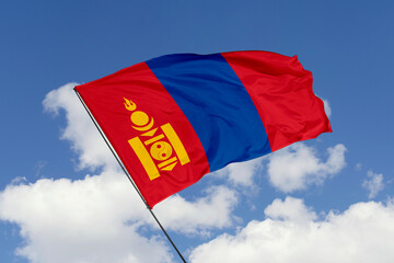 Mongolia flag isolated on the blue sky background. close up waving flag of Mongolia. flag symbols of Mongolia. Concept of Mongolia.
