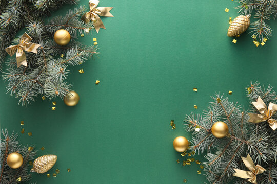 Fir branches and Christmas decorations on green background