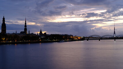 Autumn sunrise in Riga over the Daugava river against the background of the old town and the railway bridge