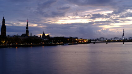Autumn sunrise in Riga over the Daugava river against the background of the old town and the railway bridge