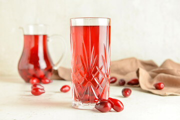 Glass of healthy dogwood berry drink on light background © Pixel-Shot