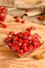 Bowl of sweet dogwood jam on wooden background