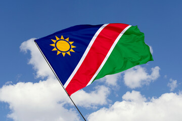 Namibia flag isolated on the blue sky background. close up waving flag of Namibia. flag symbols of Namibia. Concept of Namibia.