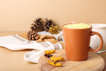 Cup of tasty turmeric latte with star anise on color background