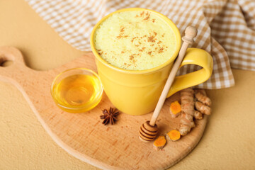Obraz na płótnie Canvas Cup of healthy homemade turmeric latte with star anise and honey on color background