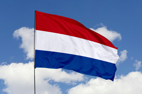 Netherlands flag isolated on the blue sky background. close up waving flag of Netherlands. flag symbols of Netherlands. Concept of Netherlands.