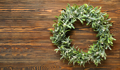 Simple mistletoe wreath on wooden background