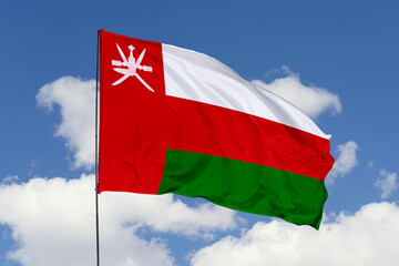 Oman flag isolated on the blue sky background. close up waving flag of Oman. flag symbols of Oman. Concept of Oman.