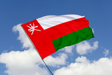Oman flag isolated on the blue sky background. close up waving flag of Oman. flag symbols of Oman. Concept of Oman.