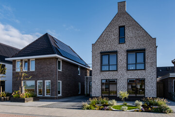 Newly build houses with solar panels attached on the roof against a sunny sky Close up of new...