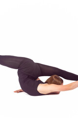 Obraz premium Sport Ideas and Concepts. Young Caucasian Sportswoman Rhythmic Gymnast In Training Black Outfit During Backward Legs Split Stretching Exercises While Laying on Floor On White.