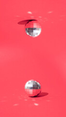 Shining silver disco balls on the floor and ceiling. Minimal New Year's in Christmas design on a red background.