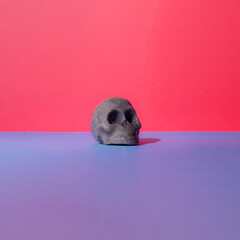 Black gray skull candle head on a  blue and red background.