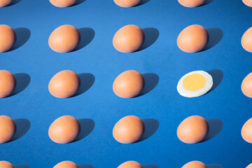 Arranged egg and the half on blue pastel background.