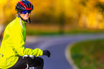 Professional Road Cycling. Caucasian Female Cyclist With Road Bike Posing Outdoors Against Autumn Background