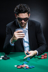 Casino Concepts. Caucasian Young Handsome Pocker Player Staking and Betting To Win At Pocker Table With Chips And Cards.