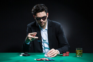 Gambling Concepts. Caucasian Young Handsome Pocker Player Staking and Betting To Win At Pocker Table With Chips And Cards